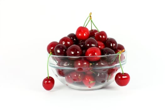 Sweet cherries in a glass bowl isolated on white