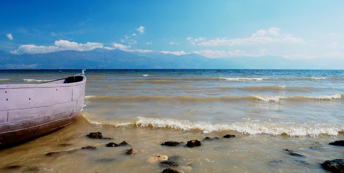 boat on beach of lake prespa, troubled water