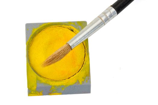 a brush and a yellow watercolor tin isolated on white