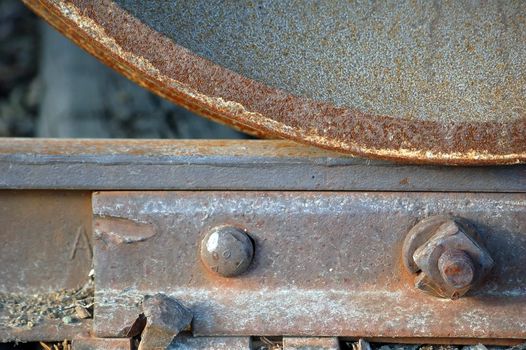 Close-up of a rusted  train's wheel on a rail