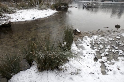 A view of a lake in winter with snow