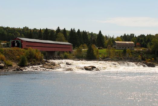 Landscape picture of a covered bridge over some rapids