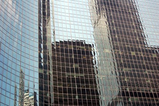 High rise buildings reflecting in the windows of a skyscraper