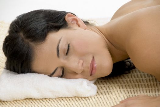 young woman sleeping on bamboo mat on an isolated white background