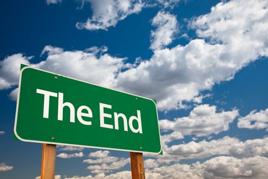 The End Green Road Sign with Copy Room Over The Dramatic Clouds and Sky.