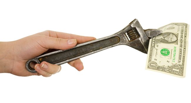 Wrench in a hand with dollar on a white background