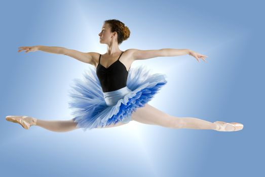 dancer in blue tutu jumpig on a shining blue background