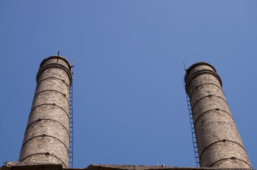 Old abandoned factory twin chimneis in Italy