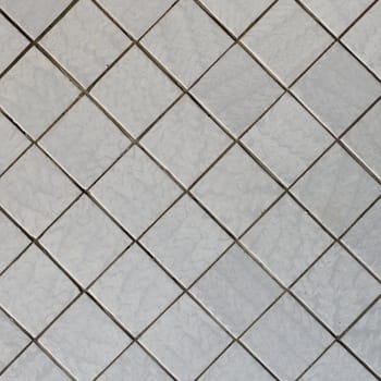 Wall covered with an old grey tile - a diagonal square texture