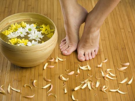 feet near a basin with flowers and water