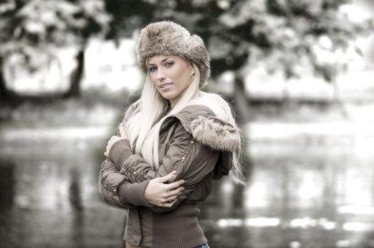 outdoor portrait of a young woman in winter dress with fur hat