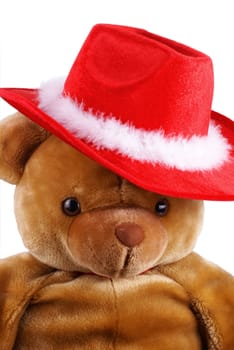 Big brown teddy bear with a santa hat on is head.