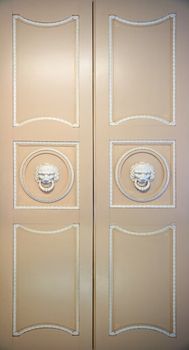 old closed ornate doors with lion head handles
