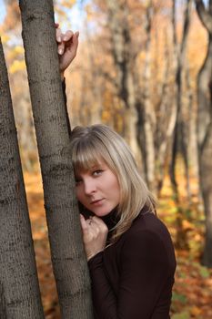 portrait of beautiful young girl near autumn tree