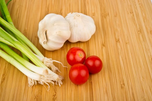 Image of Green Onions, Tomatoes, and Garlic on Cutting Board