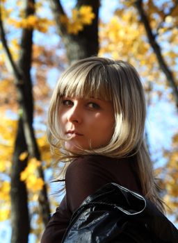 portrait of beautiful young girl on autumn background