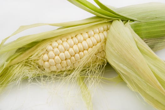 Close-up image of a partially shucked ear of corn