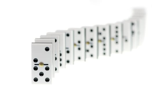 Chain of white domino stones on white background, focus on first