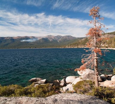 Clear sky and good view of the water, with mountains in the background.