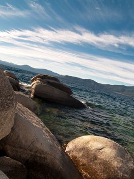 Clear view of the lake and sky, with mountains in the distance.