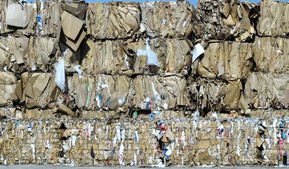 Stacks of brown cardboard boxes crushed and ready for recycling