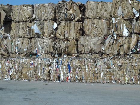 Stacks of brown cardboard boxes crushed and ready for recycling