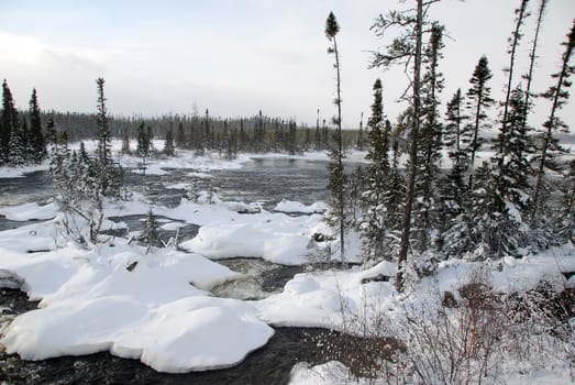 A northern river surronded by snow on a cold day