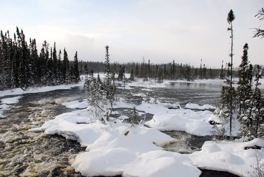 A northern river surrounded by snow on a cold day