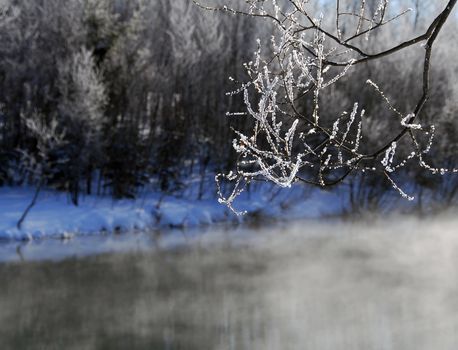 A winter landscape showing a foggy river on a cold day