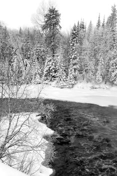 A landscape showing a frozen river in Winter