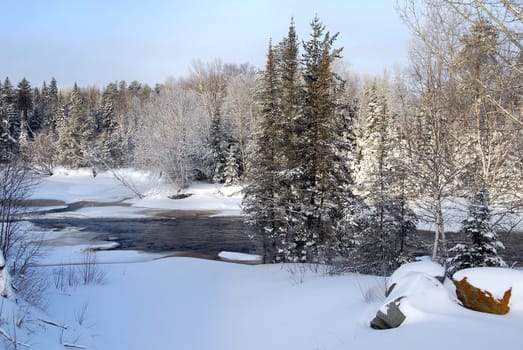 A landscape showing a frozen river in Winter