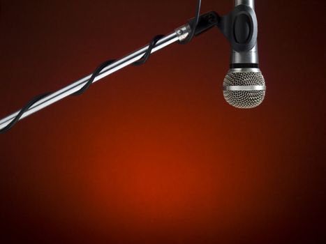 A microphone on a boom over a red background.