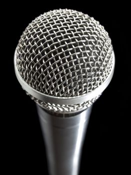 A dynamic microphone over a black background.