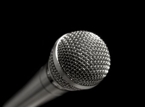 A dynamic microphone over a black background.