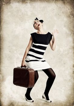 Portrait of a beautiful fashion woman posing and holding a old suitcase