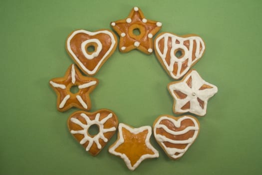 Gingerbread cookies in circle on green background