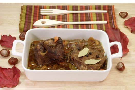 Cooked marinated beef meat in a bowl with wooden spoon.