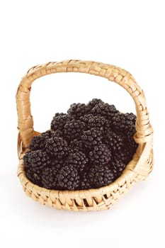 Fresh blackberries in a basket on bright background