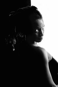 African American woman with dreadlocks against black and white wall