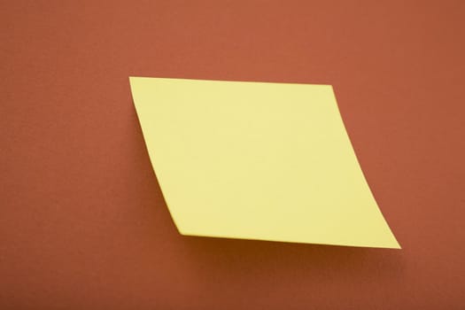 blank yellow post it on red background