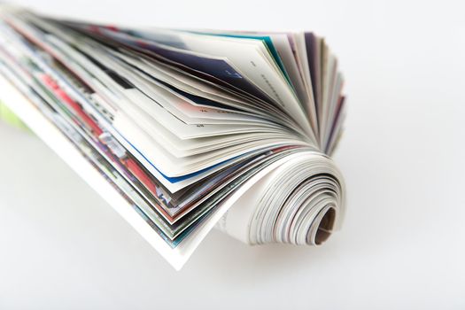 front view of roll magazine, colored newspaper on white background