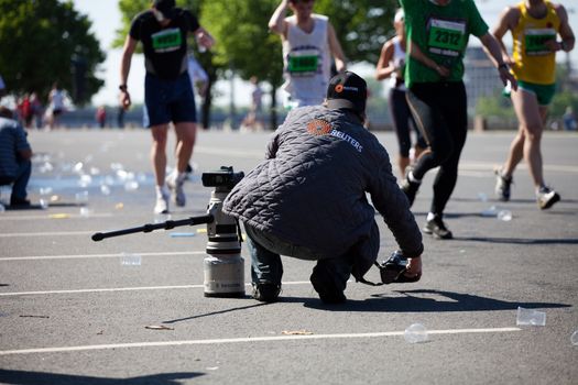 RIGA, LATVIA - MAY 23: Professional REUTERS photographer in action at Riga International Marathon on May 23, 2010 in Riga.