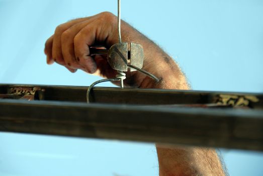 worker dirty hand with nippers and wire