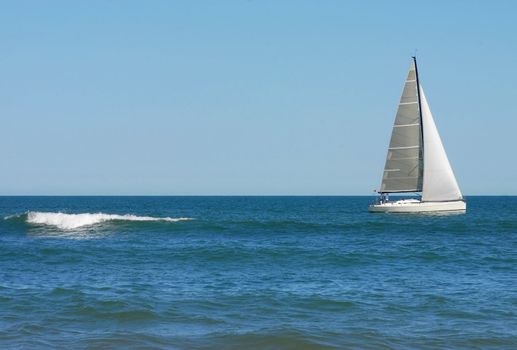 Sailing boat with small wave near the shore. Punta del Este beach. Uruguay