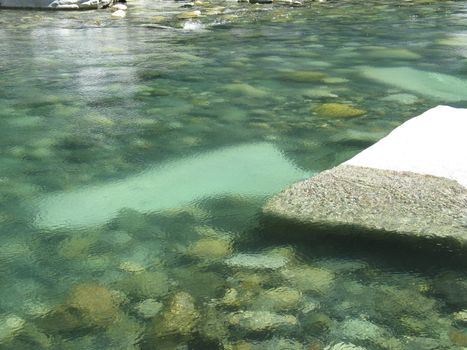 grey polished rocks and green river water