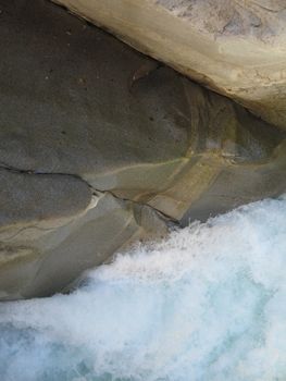 grey polished rocks and green river water