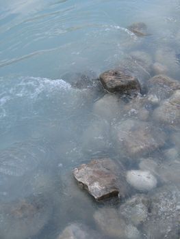 grey polished rocks and green river water