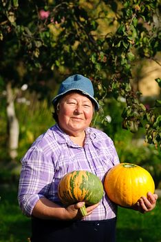 happy woman and two ripe pumpkin in garden