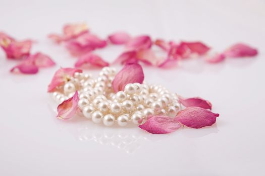 fine pearl beads and red roses petals