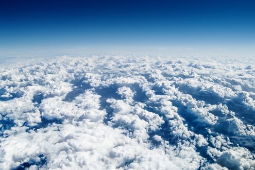 View from airplane window over the clouds